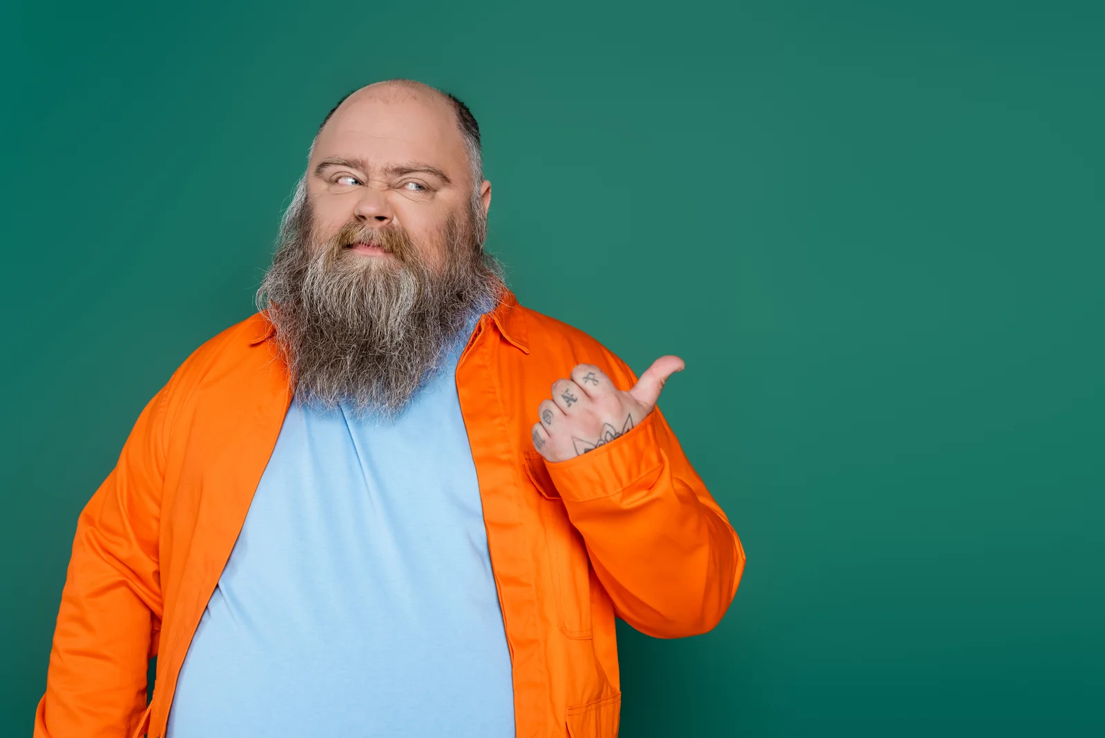 Homme en chemise orange désignant la droite sur fond vert