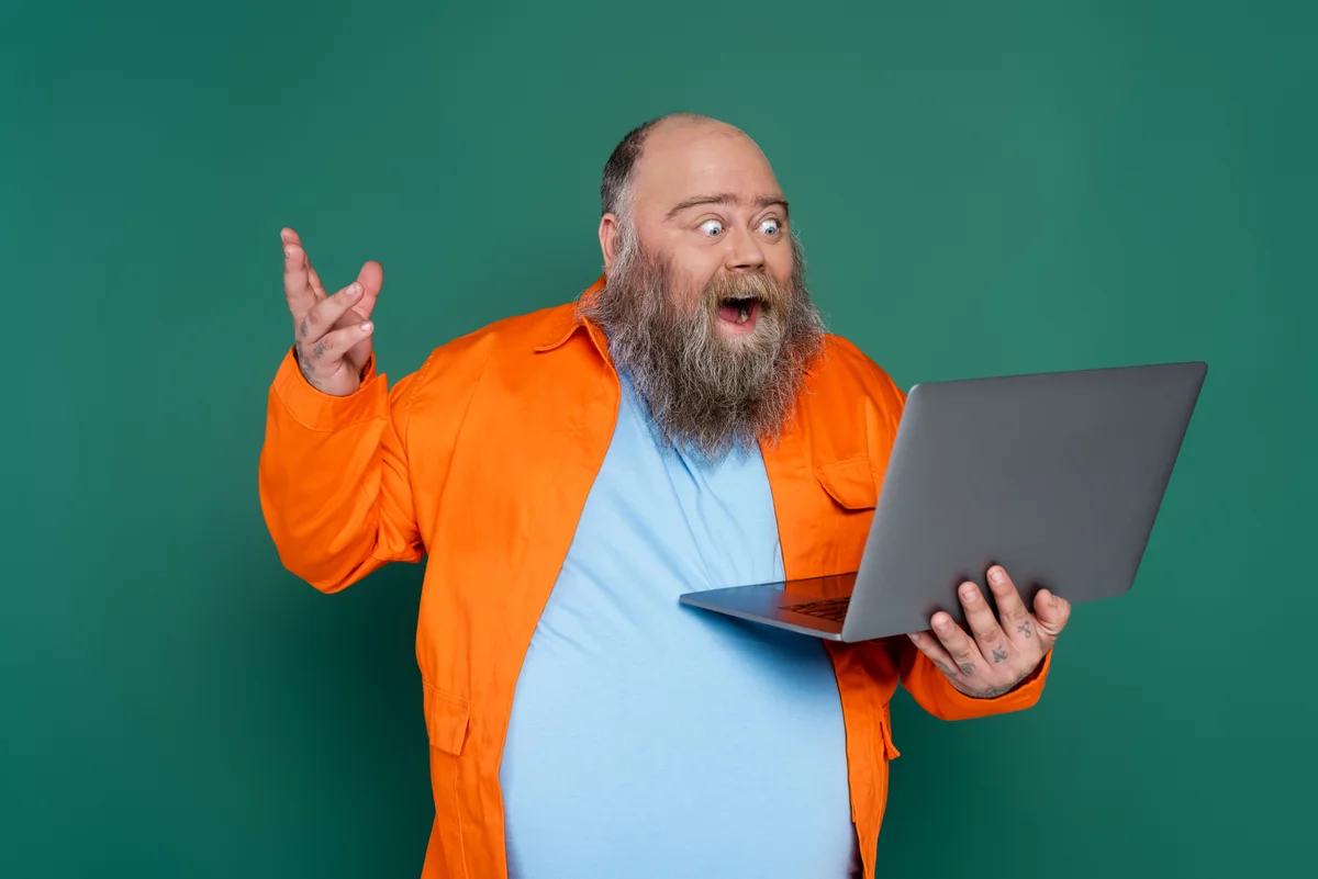 Homme surpris devant son ordinateur portable, illustrant la découverte de risques lors d'un audit Active Directory