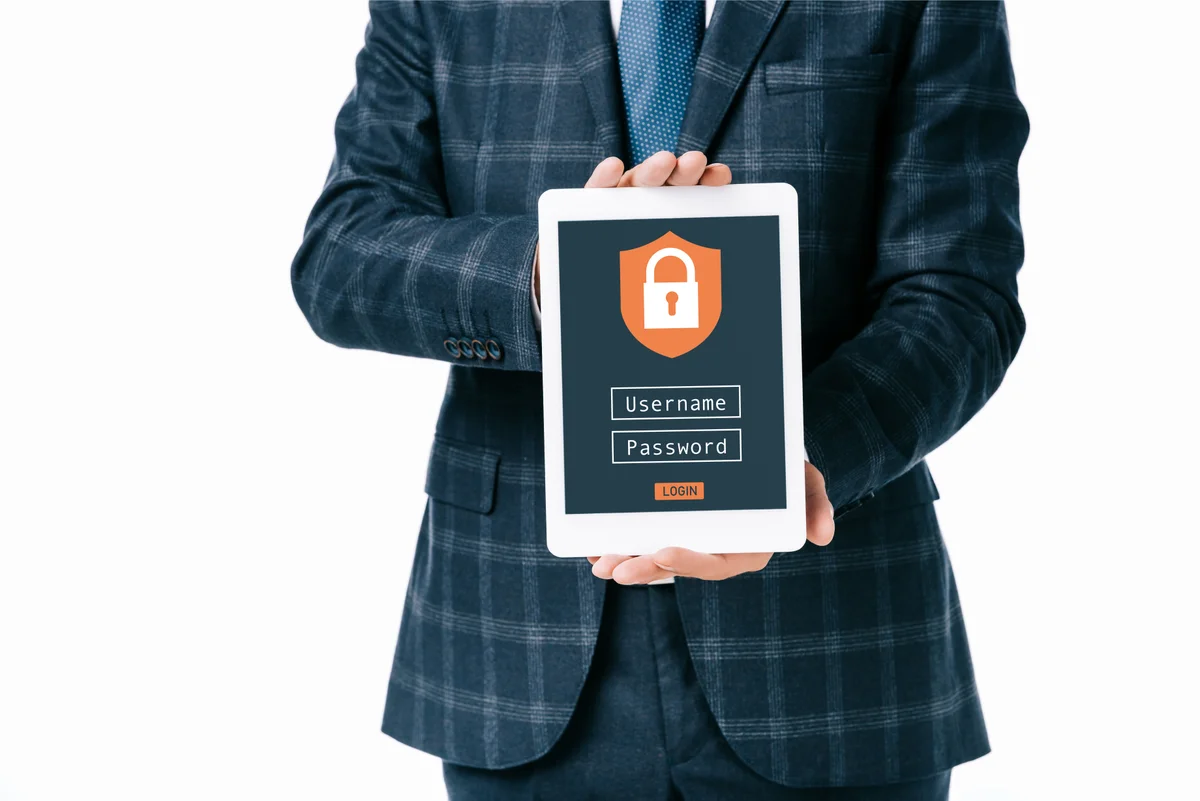 Personne tenant une tablette avec un cadenas et un écran de connexion, illustrant la protection des accès Active Directory