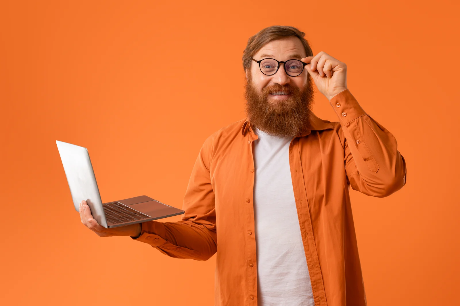Homme avec un ordinateur portable sur fond orange, illustrant l'accompagnement en sauvegarde et restauration Active Directory